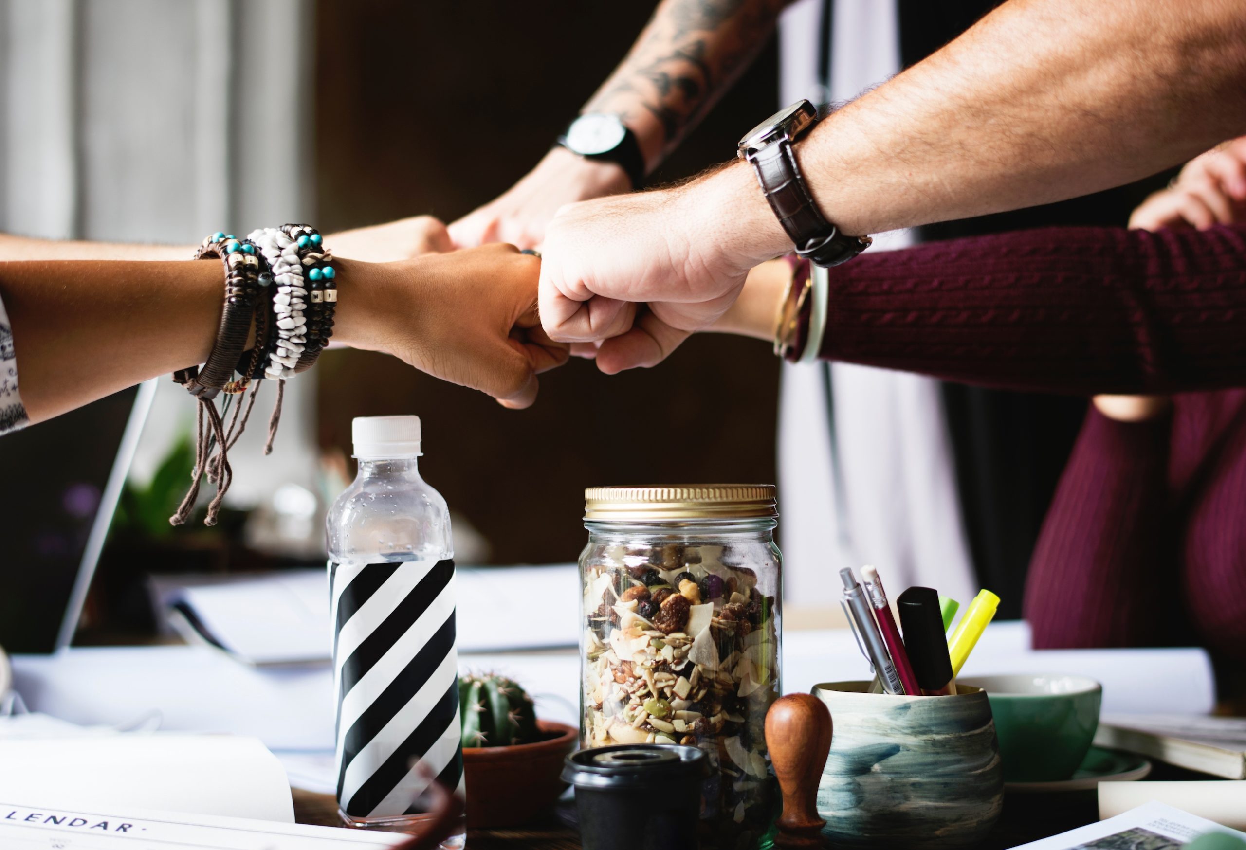 office team building fist bump desk rawpixel scaled